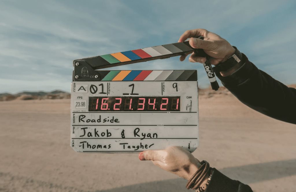 man holding clapper board to announce scene being shot for video portfolios