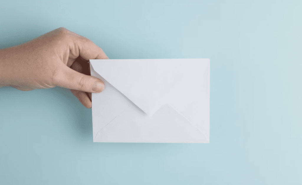 hand holding a white envelope