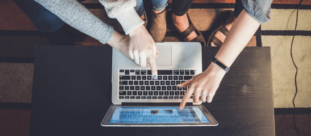 group all pointing at laptop screen