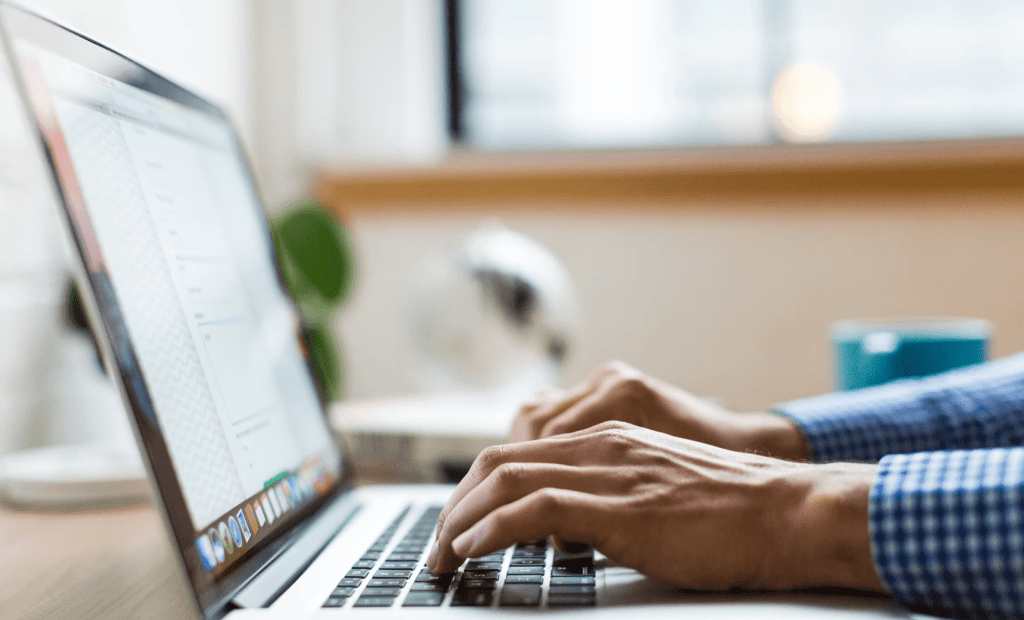 a man typing on a laptop formulating a content creation plan